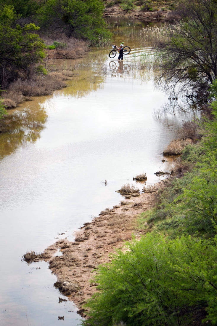 A rider cuts a lonely figure as he negotiates a creek crossing Photo: Nick Muzik/SPORTZPICS